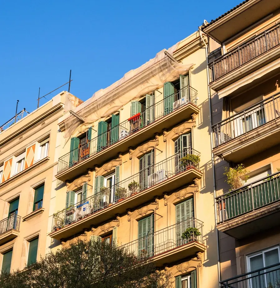 Fachada residencial de Barcelona con balcones y persianas, imagen de referencia arquitectónica